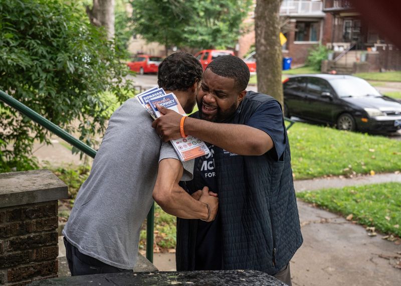 State Rep. Donavan McKinney, D-Detroit, right, gives a hug to Josh Roberts, of Detroit, while stopping at resident’s homes in Detroit’s Woodbridge neighborhood on Thursday, July 9, 2026, to talk with voters ahead of Michigan's 13th Congressional District primary.