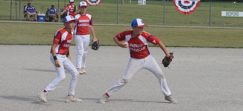 Monroe American pitcher Gavin Ball fields the ball as third baseman Geo Depew watches on the opening day of the 66th annual Monroe County Fair Baseball Tournament on Saturday, July 18, 2026.