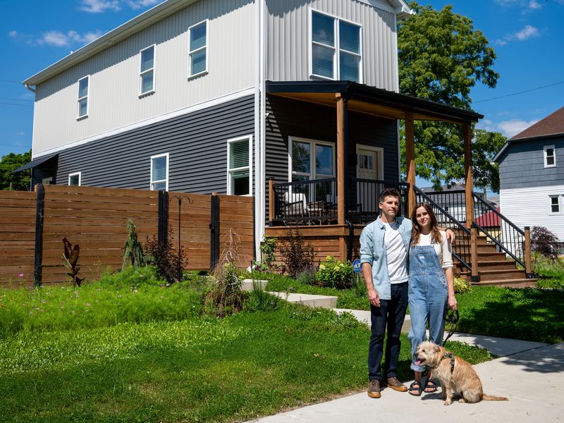 John Boros, 40, owner of Keylight Development and homeowner, stands with his wife, Meg Lockhart, 33, and their dog, Walter, outside their new-construction home in Detroit’s Islandview neighborhood on Thursday, July 23, 2026.