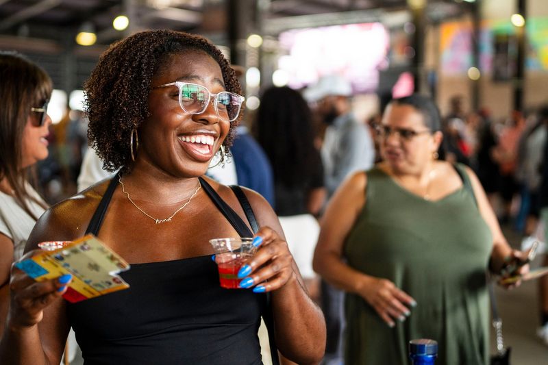 A woman smiles after receiving a Margherita drink from Paleta de Sandia at the Taco Showdown at Eastern Market in Detroit on Sunday, July 26, 2026.