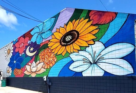 Colorful flowers and symbols covered the back wall of DNS Auto on the southwest corner of Pearl and Division streets in Downtown Coldwater.