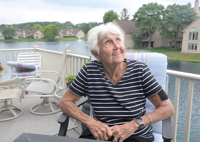 Karen Ruddy looks up from the porch of the house she shares with her daughter, Nikki Ruddy, for any passing drones, which they say fly overhead to and from the nearby Amazon Fulfillment Center in Pontiac, on Tuesday, July 28, 2026.