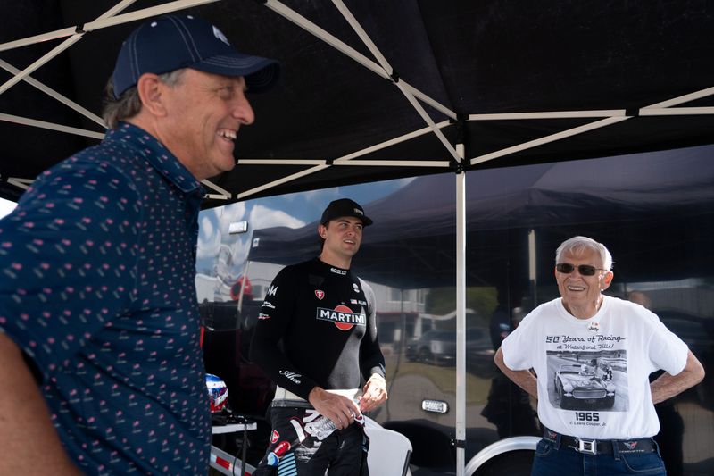 Race car driver Nolan Allaer, center, talks with his father, Rob Allaer, left, and grandfather, J. Lewis Cooper Jr., at Waterford Hills Road Racing, in Clarkston, on Friday, July 24, 2026. The passion for race cars ignited when Cooper started racing in the 1960s.