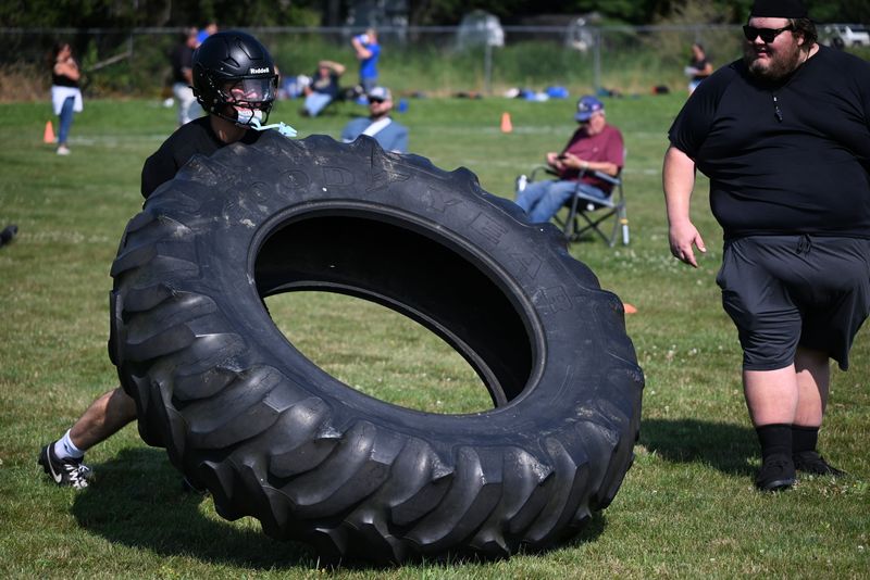 Cardinal Mooney's Riley Brohl lifts a tire during the Big Thumb Showdown at Sandusky High School on Thursday, July 30.