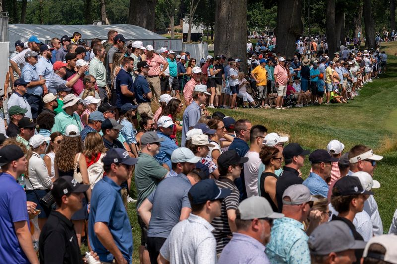 Dozens of fans line up along the 9th fairway to watch Rickie Fowler during the Rocket Classic at Detroit Golf Club in Detroit on Thursday, July 30, 2026.