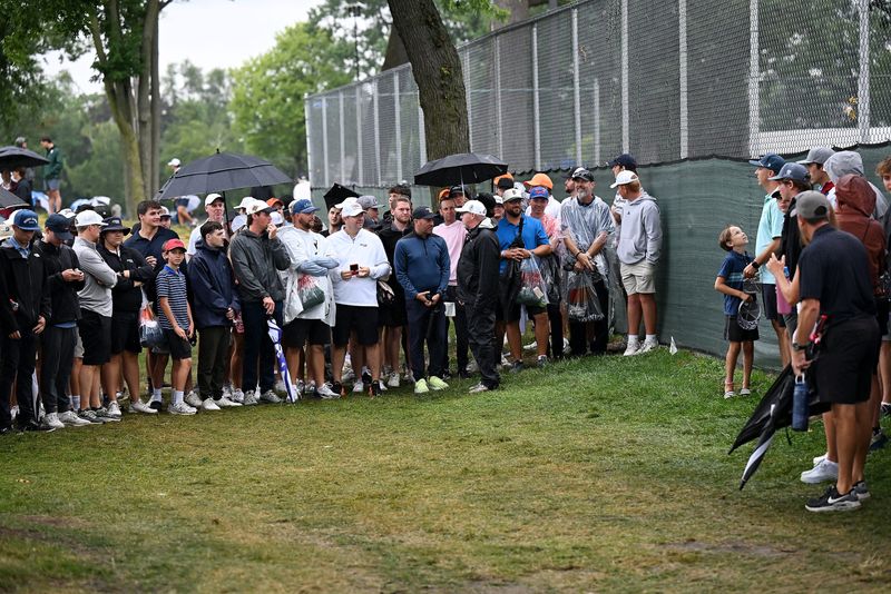Fans wait for Cameron Young to come check out where is ball ended up off of the second fairway during the final round of the Rocket Classic on Sunday, Aug. 2, 2026 at the Detroit Golf Club in Detroit.