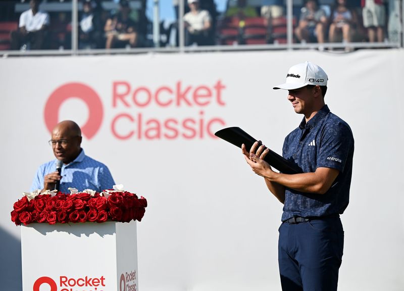 Michael Thorbjornsen holds the Rocket Classic trophy as Mike Tirico talks about Thorbjornsen's career after his first PGA Tour win on Aug. 2, 2026 at the Detroit Golf Club in Detroit.