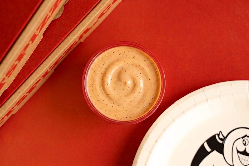 An image of a dipping cup of Jet's Pizza's limited-time Jet's Cajun Ranch sauce.