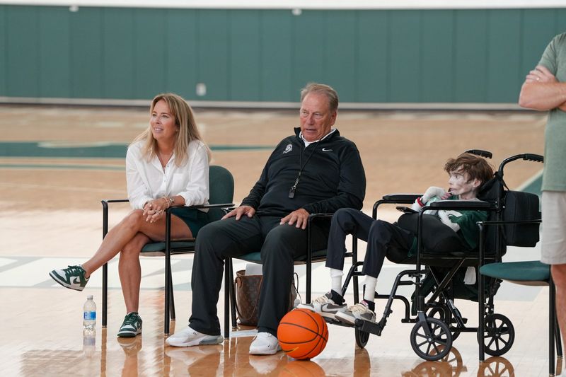 Tom Izzo, center, sits with Sam Schulz, right, and Sam's mother, Lori, during an MSU basketball practice on Tuesday, July 28, 2026.