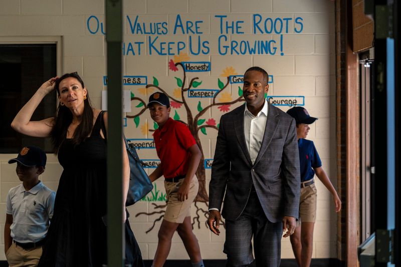 Republican gubernatorial candidate and U.S. Rep. John James walks alongside his wife, Elizabeth James and their children after arriving at Morgan Elementary School to vote during Michigan’s primary election in Shelby Township on Tuesday, Aug. 4, 2026.