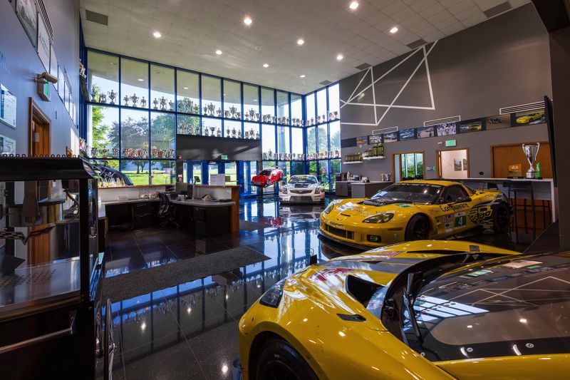 The Corvette C6.R and C8.R are displayed alongside trophies earned by Corvette Racing at Pratt Miller’s facility in New Hudson, Michigan.