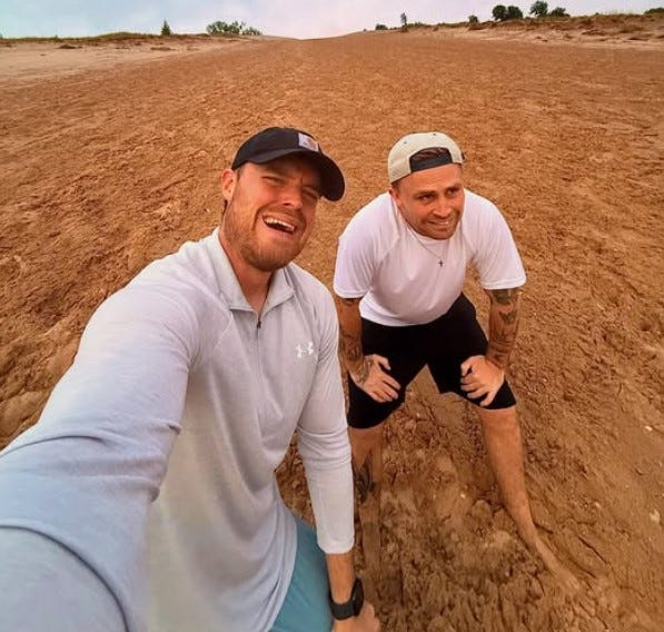 Jason Riley takes a selfie with Joshua Cauldwell-Clarke on a Michigan sand dune.