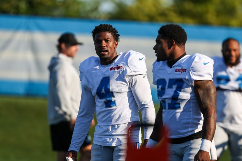 Aug 3, 2026; Allen Park, MI, USA;  Detroit Lions cornerback D.J. Reed (4) talks with defensive back Christian Izien (27) when walking onto the field before Detroit Lions training camp. Mandatory Credit: Paul Barnick-Imagn Images
