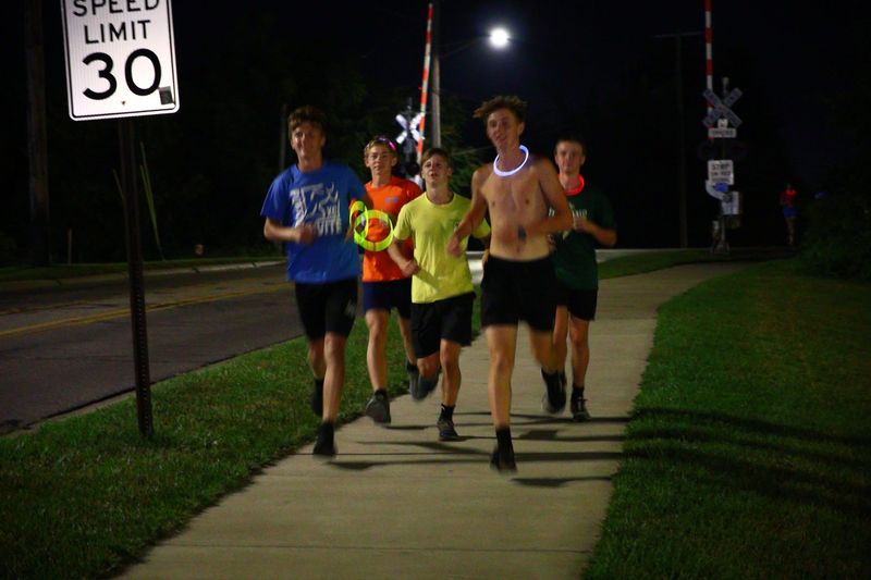Members of the St. Mary Catholic Central boys cross country team run through the streets of Monroe during their first practice for the 2026 season at 12:01 a.m. on Monday, Aug. 10, 2026.