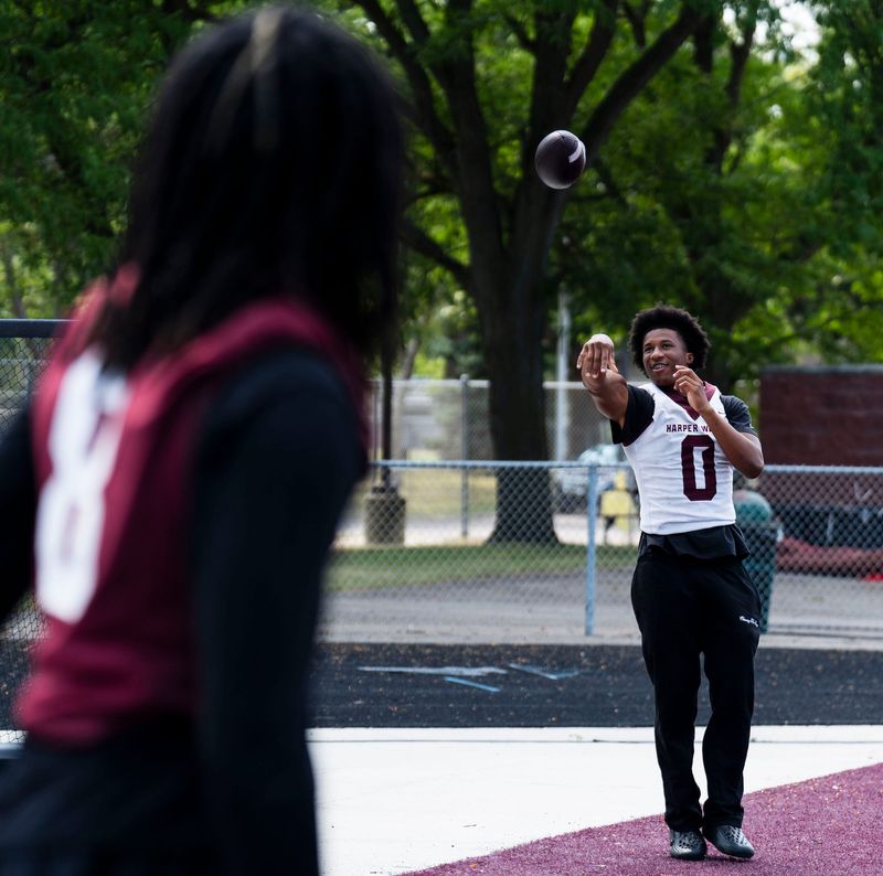 Harper Woods defensive back Jayden Evans (8), plays catch with wide receiver Dakota Guerrant (0) at Harper Woods High School football practice in Harper Woods on Monday, Aug. 10, 2026.
