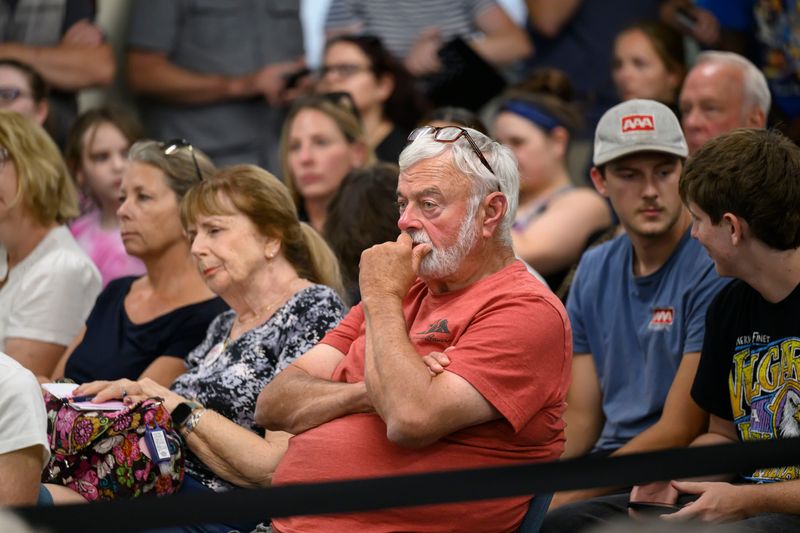 Paul Lavoie, center, listens to public comments about a proposed data center during a Lyon Township Planning Commission meeting, Aug. 10, 2026. Some township residents who oppose the center think a decision on the proposed data center should have been made at a higher level than the planning commission.