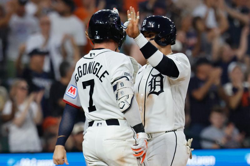 Tigers shortstop Javier Baez (28) receives congratulations from Kevin McGonigle (7) after scoring in the seventh inning against the Guardians.