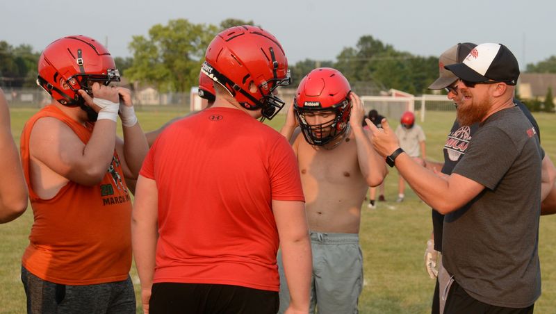 New Milan football coach Cord Trott talks to his players during a training camp practice on Tuesday, Aug. 11, 2026.