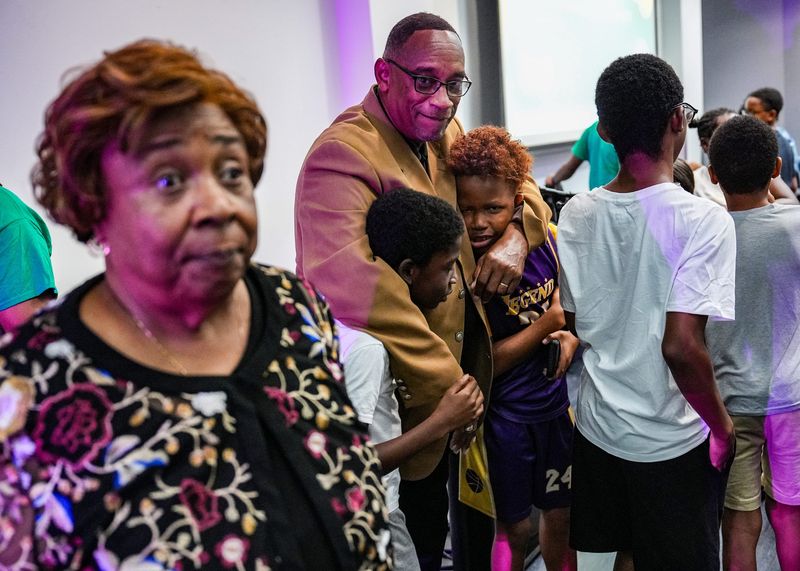 Rev. Alex Hill of Tri City Community Development Corp horse plays with youth during the Eden Park Environmental Justice Youth Ambassadors Inaugural Class Graduation Celebration at Charles H. Wright Museum of African American History in Detroit, Wednesday, August 12, 2026.