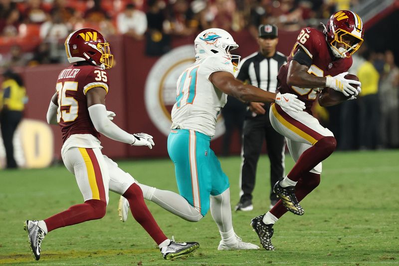 Aug 14, 2026; Landover, Maryland, USA; Washington Commanders safety Malik Spencer (36) intercepts a pass intended for Miami Dolphins safety Louis Moore (41) during the second half at Northwest Stadium. Mandatory Credit: Geoff Burke-Imagn Images