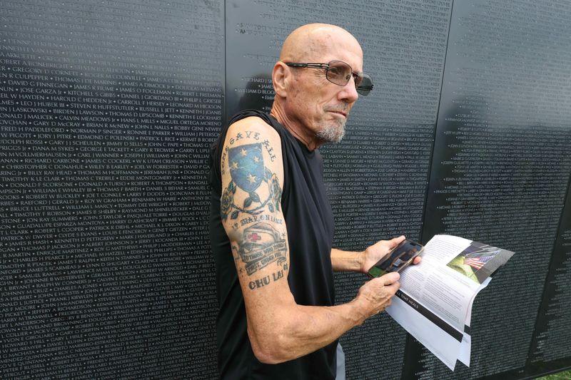 Ralph Evans shows his tattoo honoring Sharon Lane, whose name is etched on the Wall that Heals at Heritage Park, Saturday, Aug. 15, 2026 in Taylor, Mich.