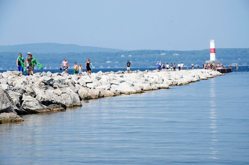 People walk along the breakwater in Petoskey.