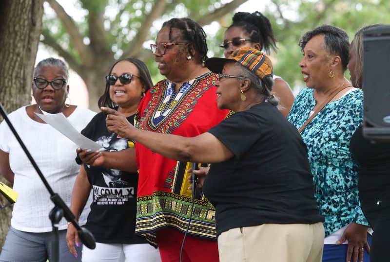 Crystal Hayman Simms (front, with hat) leads the singing of "Lift Every Voice and Sing" to open the Juneteenth celebration at the George Wilson Center and Park in Newark on June 17, 2023.