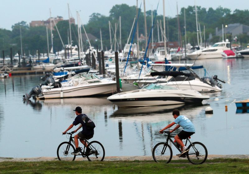 Kids ride their bikes along the water in Harbor Island Park in Mamaroneck June 30, 2023. The 44-acre tract next to Mamaroneck Harbor offers a playground, beach, boat launch and sports fields. Most of the park sits atop soil, rock and other materials used to fill in environmentally valuable tidal wetlands in the early 20th Century.