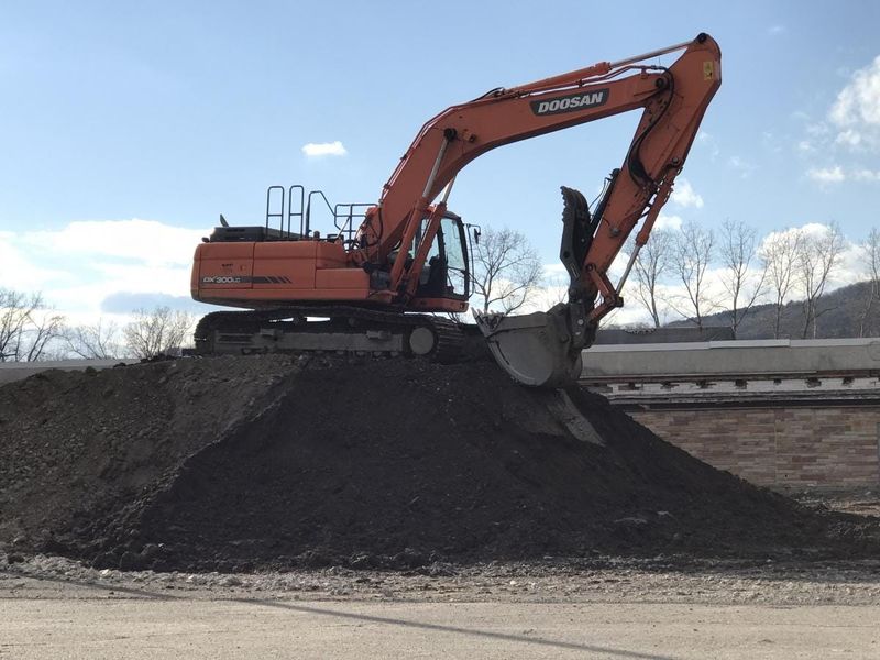 A track hoe sits atop a pile of fill during the early construction phases at a site in Hornellsville set to house St. James Mercy Hospital's new site in 2019. [PHOTO PROVIDED]