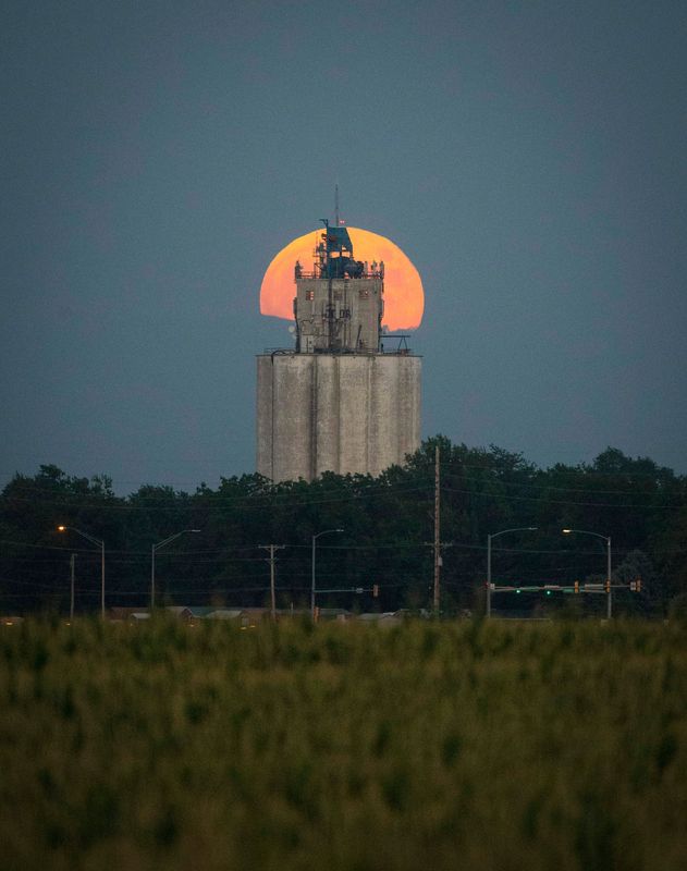 The full buck moon rises behind a grain elevator in Waukee, Iowa, on July 16, 2019. The full moon coincided with the 50th anniversary of the launch of Apollo 11 that year.