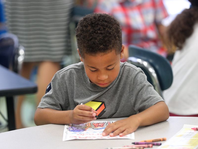 Esaias Ortiz colors during the start of class on the first day of school at Ivan Green Primary School in Irondequoit in 2019.