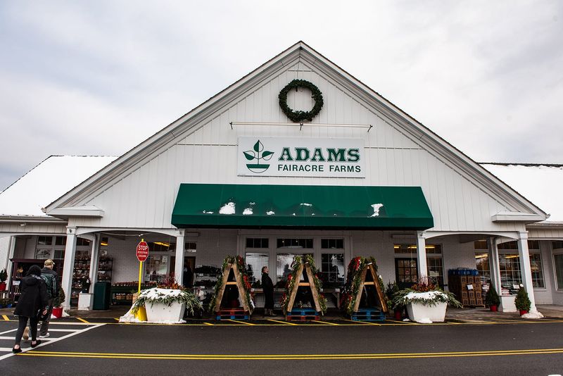 The exterior of an Adams Fairacre Farms store, featuring the traditional peaked roof over the entrance and green-and-white motif.