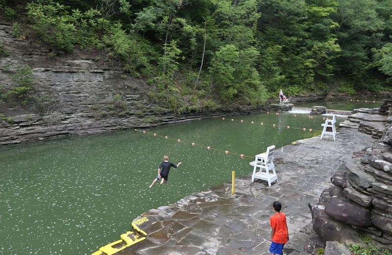 A brave youth makes a running leap into the deepest section of the naturally formed swimming pool at Stony Brook State Park in 2015.