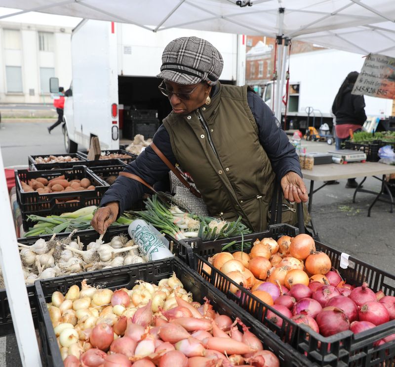 Velma Broderick from the Bronx looks through a selection of garlic from Dan Madura Jr. Farms at the Nyack Farmers Market in Nyack on Thursday, April 11, 2019.