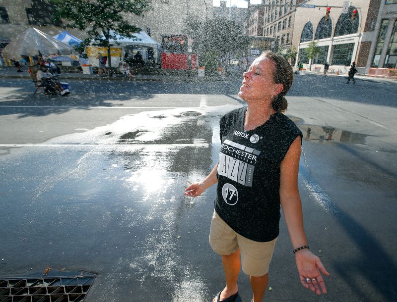 Stephanie Dawson of Greece cools down with a water spray on Chestnut Street during the Xerox Rochester International Jazz Festival earlier this summer. The National Weather Service has issued a heat advisory for Monday.
