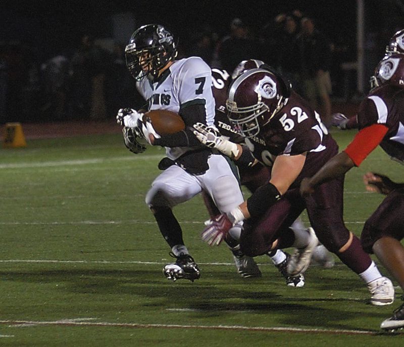 East defenders Alex Daines (72) and Pelham McClellan try to take down West running back Brian Guilfoyle. Both Daines and McClellan will be inducted into the Corning-Painted Post Sports Hall of Fame in 2026.