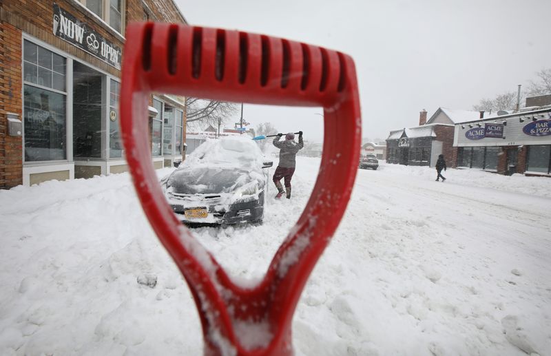Nicole Hale, Rochester, digs her buried car out from under nearly a foot of snow as the first major snowstorm blanketed Rochester and western New York on Monday, Jan. 17, 2022.