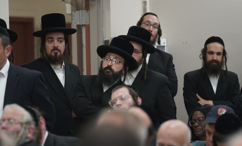 Zev Tarkieltaub, center, listens to remarks during a public hearing on a petition to create a village within the borders of the towns of Thompson and Fallsburg at Viznitz Institutions synagogue in Kiamesha Lake on Thursday, August 3, 2023.