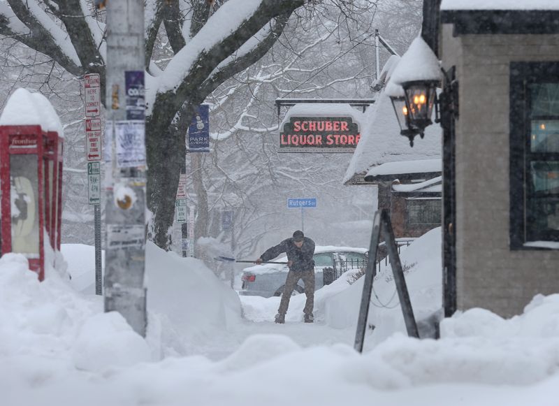 Cory Schuber, Rochester, shovels off the sidewalks surrounding his families' business, Schuber Liquor Store, on Park Avenue in Rochester Tuesday, Feb. 16, 2016. This is already the third time I've shoveled, and it's not even noon," he laughed. "I love it! It's so beautiful out."