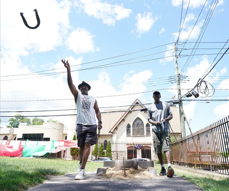 Daryl "Rock" Ross, left, and Felix "Man" Sloan from Conn. play in a horseshoe tournament at Lincoln Park in New Rochelle on Saturday, Jun 8, 2024 as part of a month-long Juneteenth celebration.