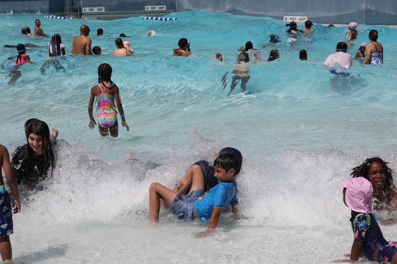 Waves crash over patrons at Willson's Waves wave pool at Willson's Woods Park in Mount Vernon July 10, 2024, as they try and beat the heatwave like weather that the area has been experiencing.