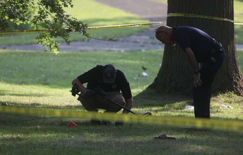 Rochester police use a metal detector to find bullet casings in Maplewood Park in Rochester, NY, Monday morning, July 29, 2024. Tyasia Manning, 25, and Phylicia Council, 34, received fatal gunshot wounds that also injured five others after multiple gunshots were fired at a gathering in Maplewood Park yesterday.