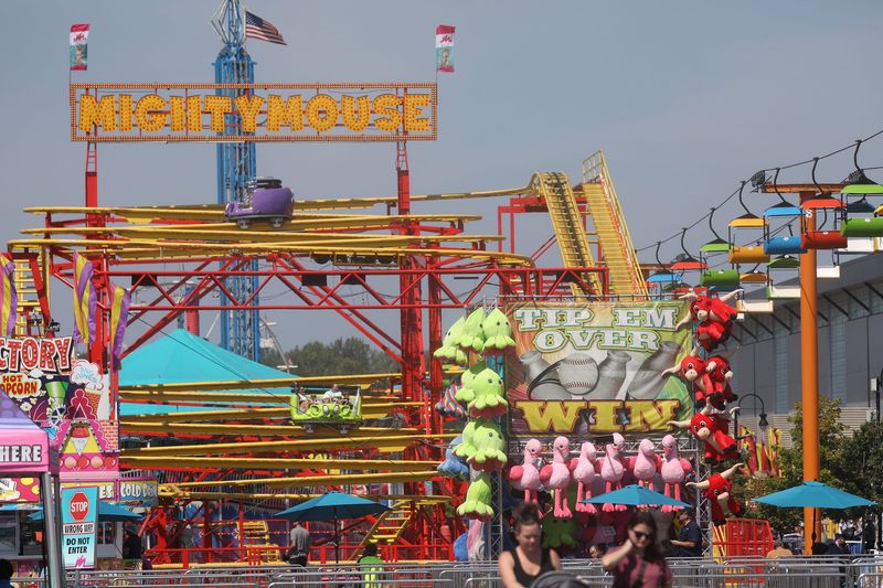 Two cars ride along the tracks of the Mighty Mouse ride at the New York State Fair in Syracuse on August. 27, 2024. Games, rides and food booths are mixed together at the midway.