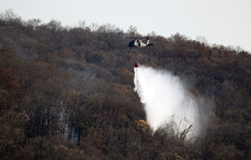 An Army National Guard helicopter uses a helibucket to drop water on the Jennings Creek fire in Greenwood Lake. Tuesday, November 12, 2024.