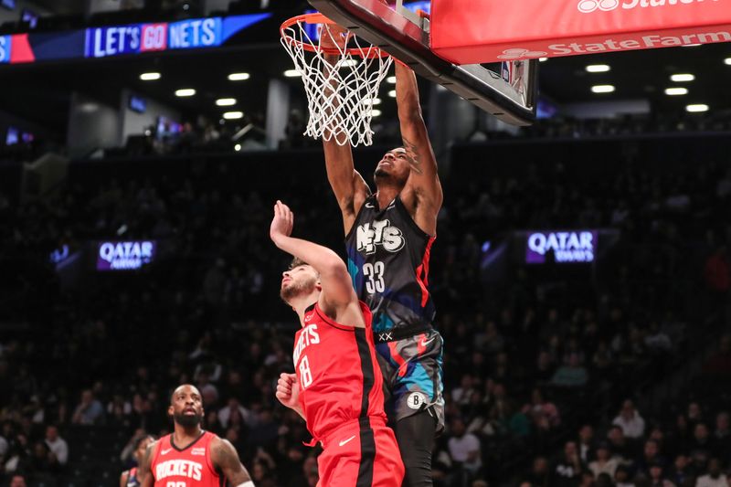 Jan 27, 2024; Brooklyn, New York, USA; Brooklyn Nets center Nic Claxton (33) dunks over Houston Rockets center Alperen Sengun (28) in the first quarter at Barclays Center. Mandatory Credit: Wendell Cruz-USA TODAY Sports