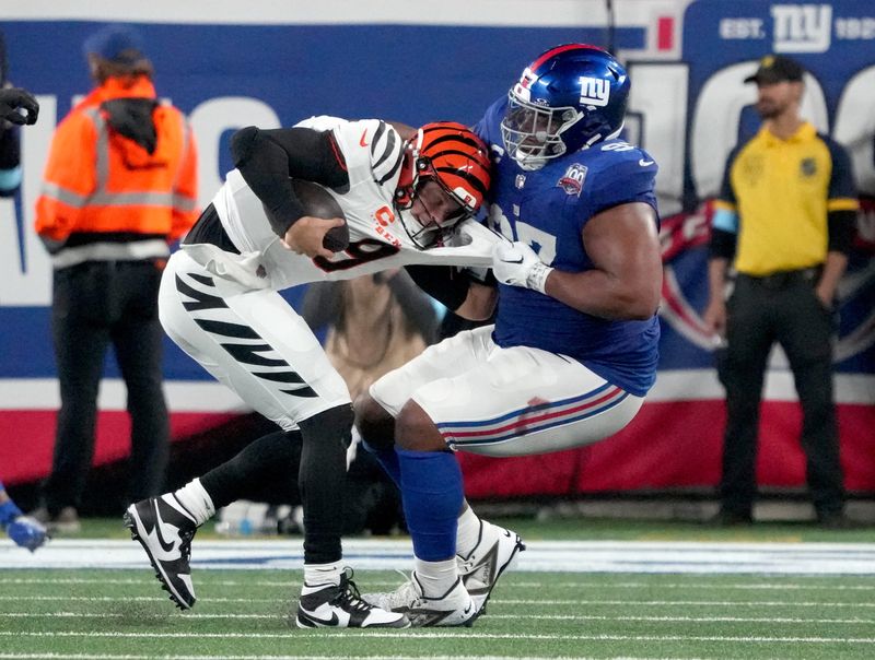 Oct 13, 2024; East Rutherford, New Jersey, USA; Cincinnati Bengals quarterback Joe Burrow (9) is sacked by New York Giants defensive tackle Dexter Lawrence II (97) in the 3rd quarter at MetLife Stadium. Mandatory Credit: Robert Deutsch-Imagn Images