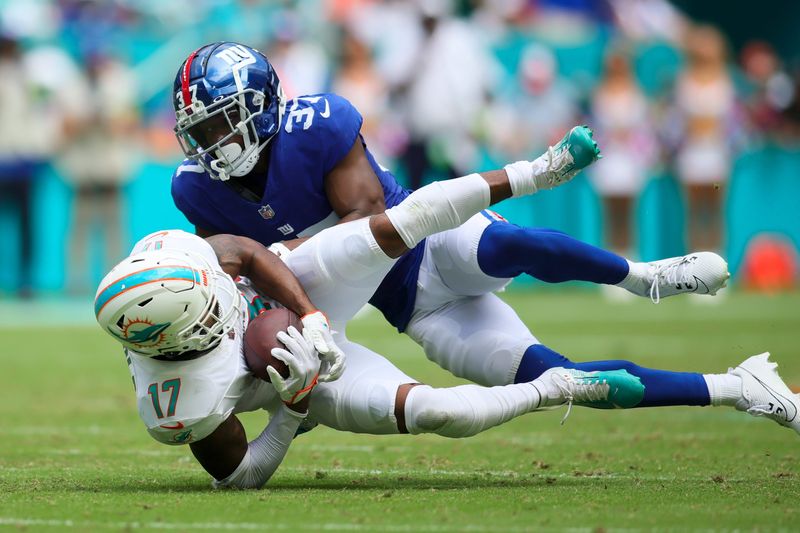 Oct 8, 2023; Miami Gardens, Florida, USA; Miami Dolphins wide receiver Jaylen Waddle (17)catches the football against New York Giants cornerback Tre Hawkins III (37) during the second quarter at Hard Rock Stadium. Mandatory Credit: Sam Navarro-USA TODAY Sports