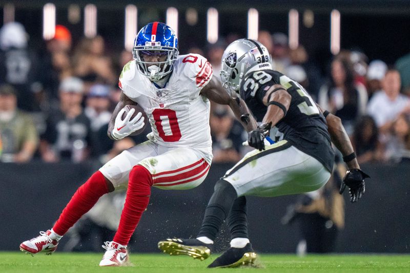 November 5, 2023; Paradise, Nevada, USA; New York Giants wide receiver Parris Campbell (0) runs the football against Las Vegas Raiders cornerback Nate Hobbs (39) during the fourth quarter at Allegiant Stadium. Mandatory Credit: Kyle Terada-USA TODAY Sports