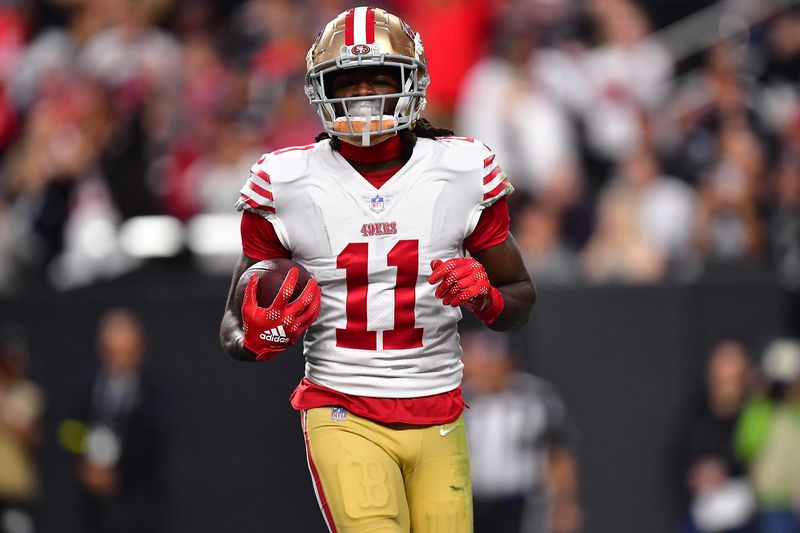 January 1, 2023; Paradise, Nevada, USA; San Francisco 49ers wide receiver Brandon Aiyuk (11) scores a touchdown against the Las Vegas Raiders during the first half at Allegiant Stadium. Mandatory Credit: Gary A. Vasquez-USA TODAY Sports