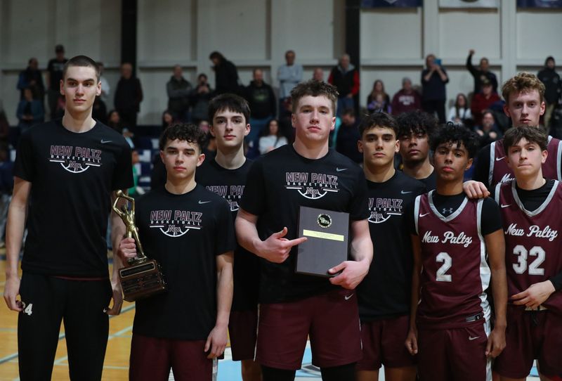The New Paltz boys basketball team with the MHAL boys basketball championship trophy and plaque after defeating Ellenville on February 26, 2025.